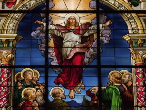 Stained glass resurrection / bright cross / church light streaming in.