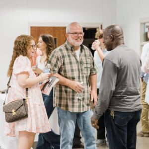 Church people greeting, serving food, smiling fellowship, hugs.