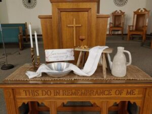 A worship-centered image reflecting joyful praise, Christian discipleship, gratitude, and faithful service. The scene connects the symbolism of the worship table — including maracas, tambourine, cross and flame, and bowl and pitcher — with the call to worship God joyfully and serve others with compassion, humility, and love.