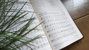 A worship-filled church sanctuary with believers singing together in reverence and joy as the words of the Doxology rise in praise. Warm light, hymnals, stained glass, and gathered worshipers reflect the beauty of Christian worship, thanksgiving, and the shared voice of the church lifting praise to God.